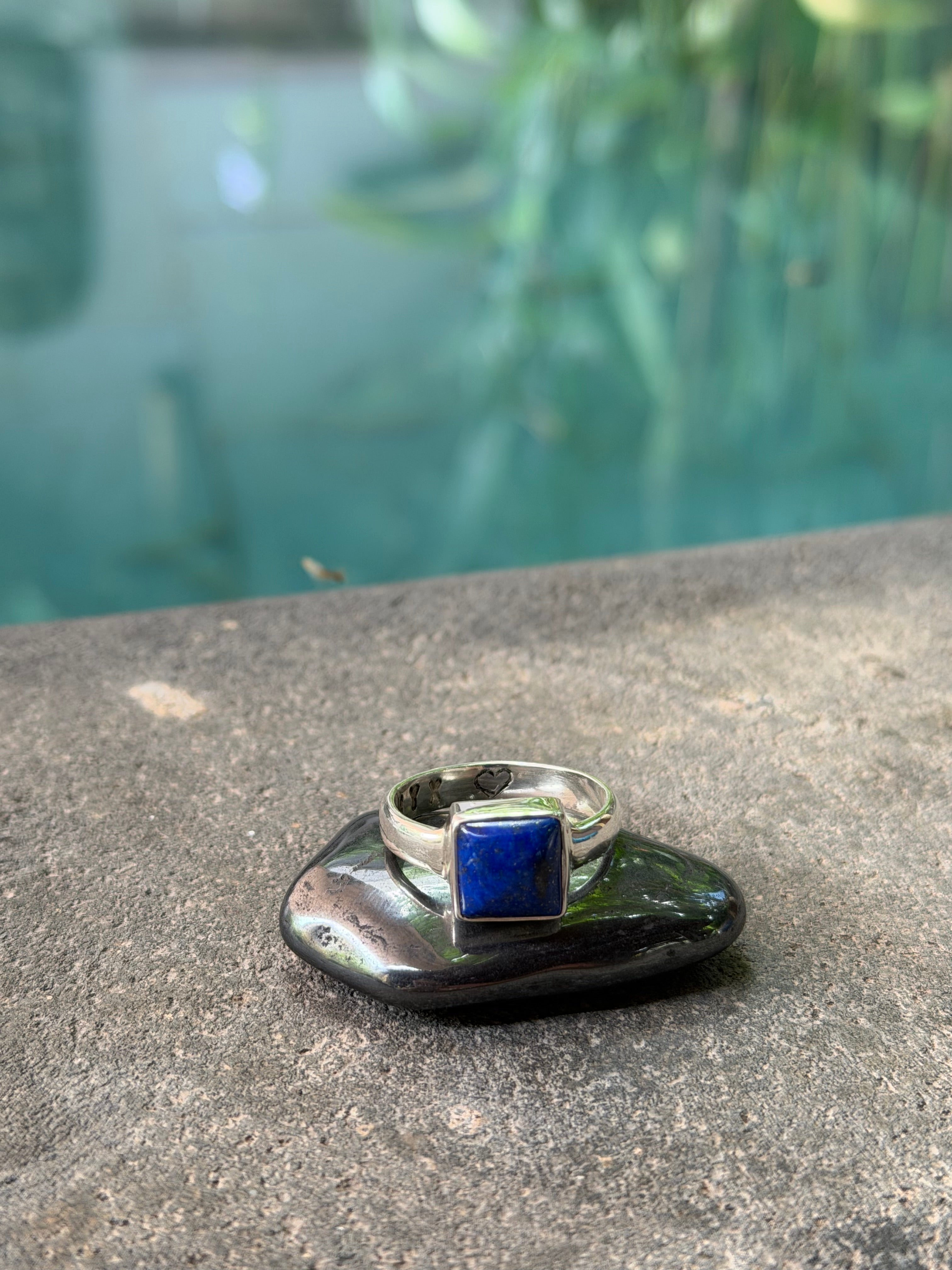 Silver ring with a blue Lapis Lazuli stone on a stone surface